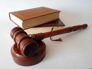 Gerichtshammmer vor Gesetzbuch